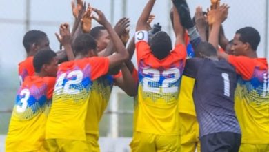 Imperial FC players celebrate passionately after scoring a goal in a Nationwide League One match, showcasing team spirit and youthful energy.