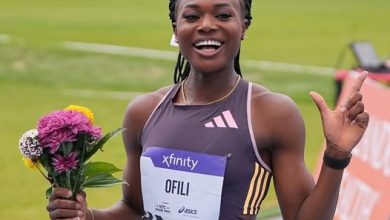 Favour Ofili celebrates after breaking the women's 150m world record, holding a bouquet of flowers at the Adidas Atlanta City Games.