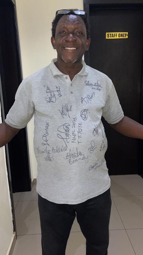 Moses Bako proudly wearing a white shirt autographed by referees at the NWFL Super 6 tournament in Ikenne