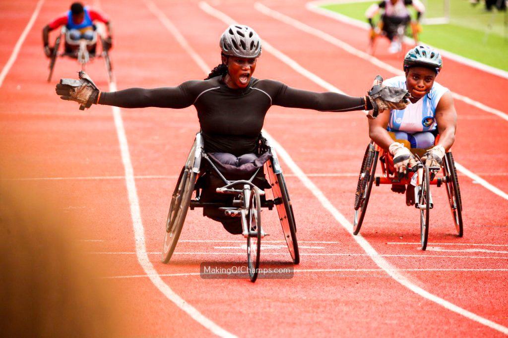 Oluwakemi Oladipo celebrating with her arms spread wide as she crosses the finish line first in the Women's T53-54 100m Wheelchair Race at the Gateway Games 2024