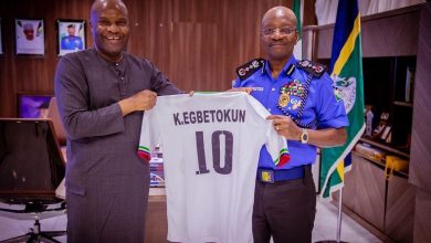 Waidi Akanni presents a framed Super Eagles No. 10 jersey to Inspector General of Police Olukayode Egbetokun during a courtesy visit in Abuja