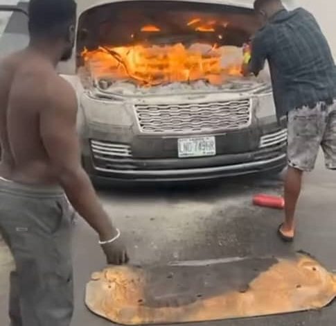 A burnt car on 3rd Mainland Bridge in Lagos, showing bystanders working to extinguish the fire.