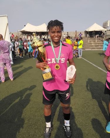 Julianah James smiling and holding the Lagos Women’s State League trophy, MVP plaque, and wearing her gold medal around her neck.