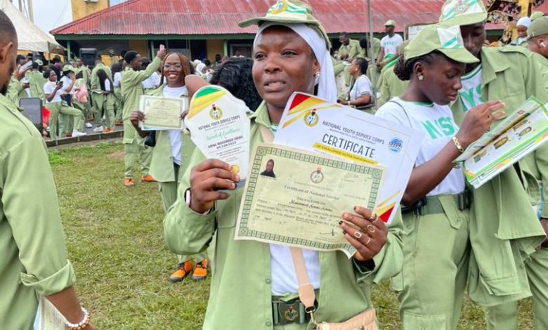 Amina Aminu Mohammed, NYSC corps member in Ibadan North, holding her Certificate of National Service and an award plaque after the 2025 Passing Out Parade