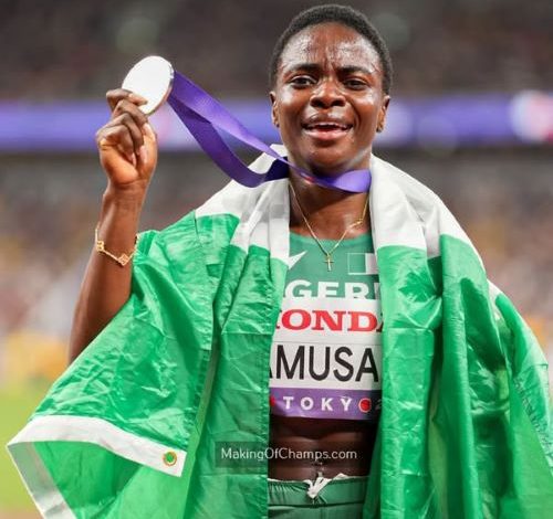 Tobi Amusan celebrates her silver medal at the Tokyo 2025 World Athletics Championships with the Nigerian flag draped around her neck.